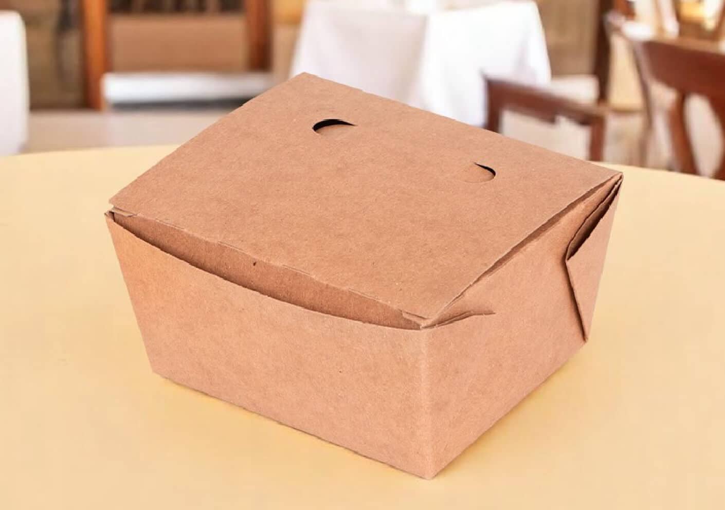 Folded brown paper takeout box sitting on a restaurant table